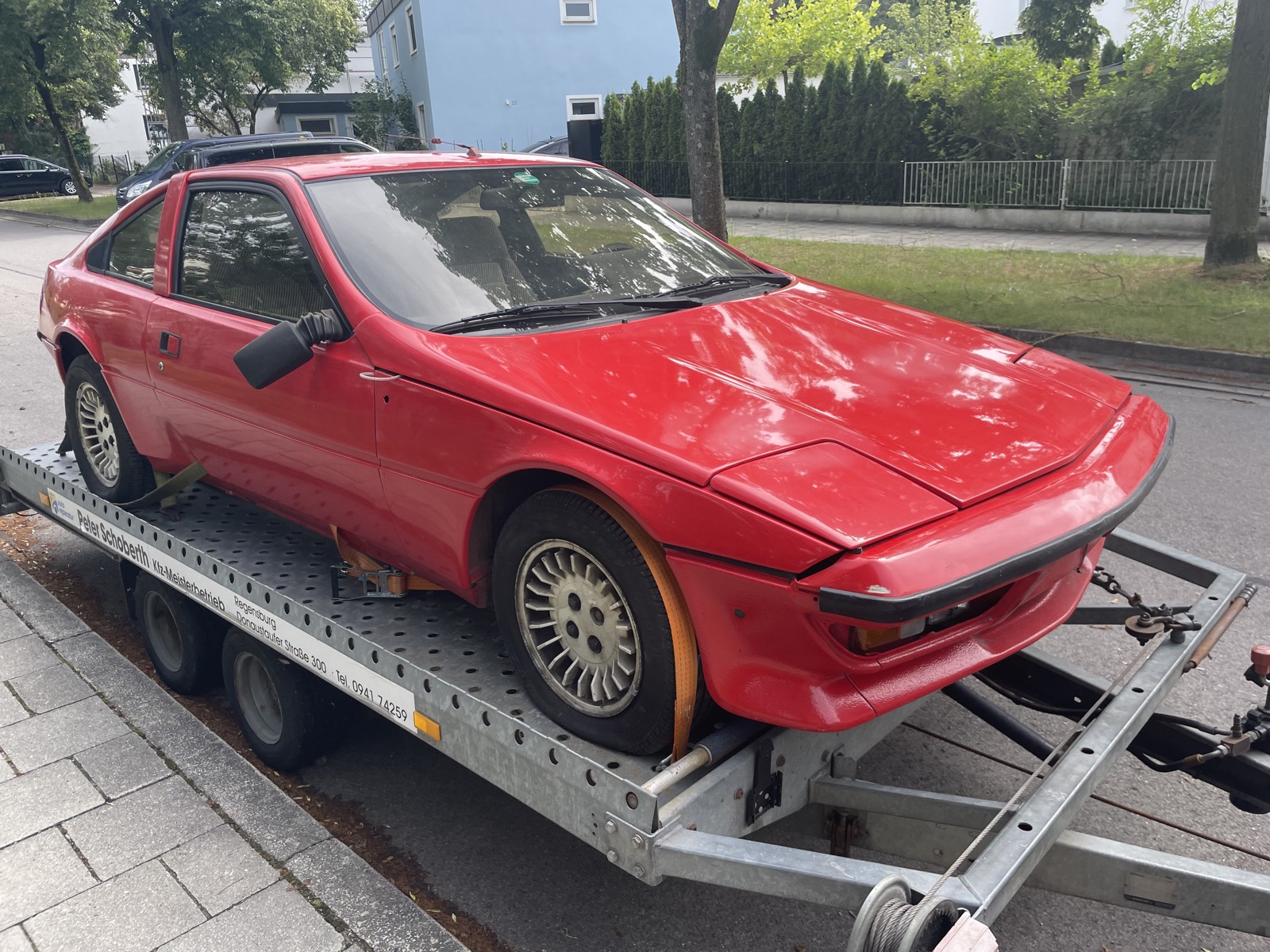 Alter roter Sportwagen auf dem Anhänger