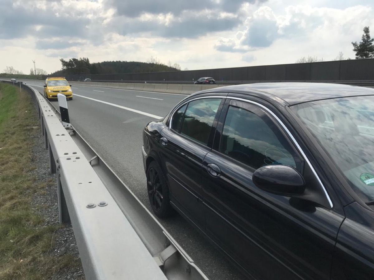 Auto auf dem Standstreifen, der Pannendienst naht